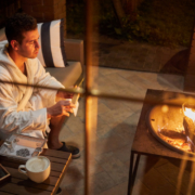 Man in robe drinks coffee in front of the fire - MarriageHeat