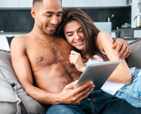 Man and woman reading on tablet together - MarriageHeat