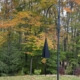 metal wind chimes on a shepard's crook in a backyard setting